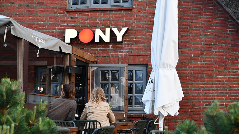 464877070.jpg       -  Zwei Frauen sitzen auf der Terrasse des Club „Pony“ in Kampen (Sylt). Hier hatten Party-Gäste zu Pfingsten rassistische Lieder gegrölt.