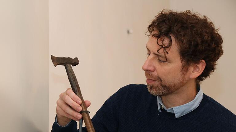 Museumsleiter Nicolas Zenzen bereitet den rund 84 Zentimeter langen Holzstab mit dem eisernen Kopfstück für seine Präsentation in der Vitrine vor. Zu dem 'Förstergerät' hat er viele Fragen. Thomas Malz       -  Museumsleiter Nicolas Zenzen bereitet den rund 84 Zentimeter langen Holzstab mit dem eisernen Kopfstück für seine Präsentation in der Vitrine vor. Zu dem 'Förstergerät' hat er viele Fragen. Thomas Malz