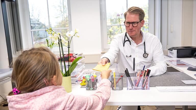 Ein Hausarzt uebergibt einem jungen Mädchen den Impfausweis - Eine Grippeschutzimpfung wird gesunden Kindern zwar nicht empfohlen. Es kann aber Gründe geben, warum der Piks für den Nachwuchs trotzdem sinnvoll ist. Ein Hausarzt uebergibt einem jungen Mädchen den Impfausweis - Eine Grippeschutzimpfung wird gesunden Kindern zwar nicht empfohlen. Es kann aber Gründe geben, warum der Piks für den Nachwuchs trotzdem sinnvoll ist.