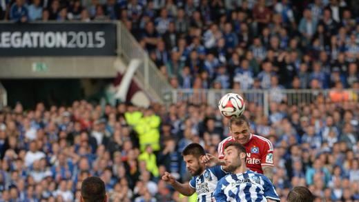 Dreikampf       -  Pierre-Michel Lasogga kommt gegen zwei Karlsruher zum Kopfball. Foto: Marijan Murat