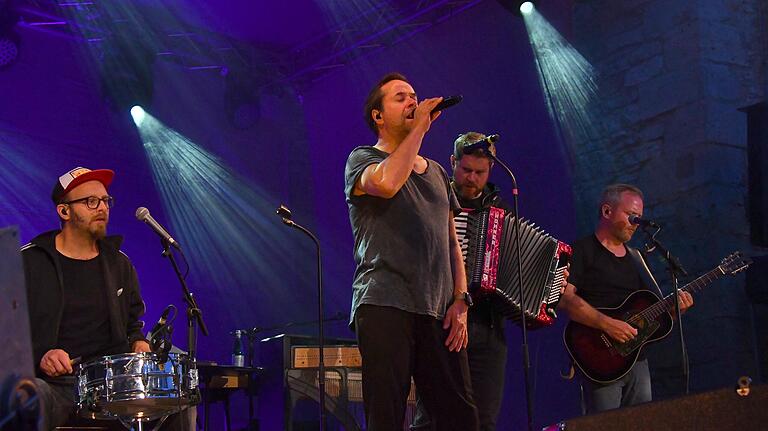 Jan Josef Liefers in Aktion mit seiner Band Radio Doria beim Konzert auf Burg Brattenstein in Röttingen.