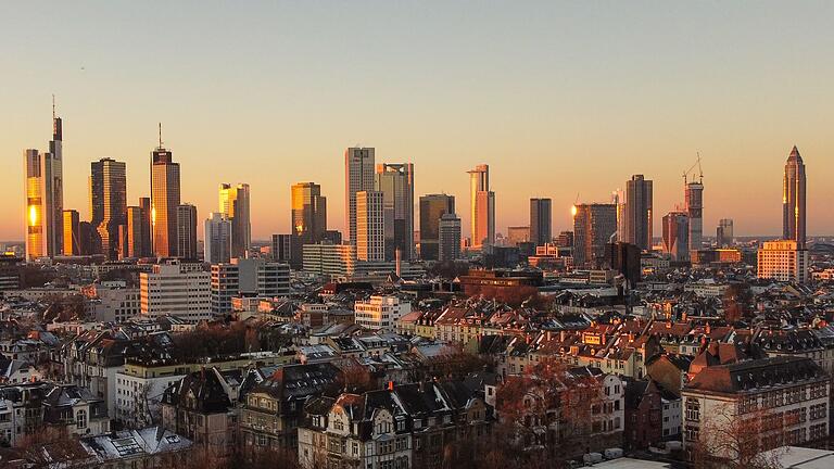 Aufgehende Sonne in Frankfurt       -  Das Licht der aufgehenden Sonne streift die Hochhäuser der Skyline von Frankfurt.