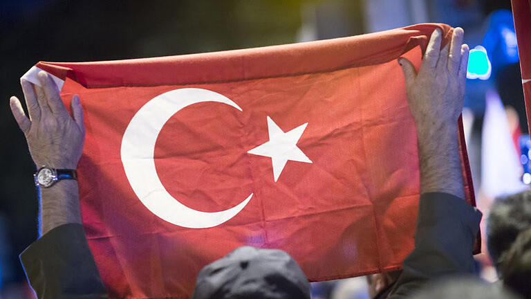 Putschversuch in der Türkei       -  Ein Mann hält bei einer Demonstration vor dem türkischen Generalkonsulat in Hamburg eine türkische Fahne. Foto: Paul Weidenbaum