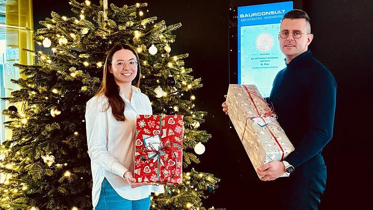 Marketingleitung Dr. Marina Willinger und Gesellschafter Sebastian Kuhn freuen sich über die Weih-nachtsgeschenke, die für die Weihnachtsbaum-Aktion des Landkreises Haßberge gesammelt wurden.