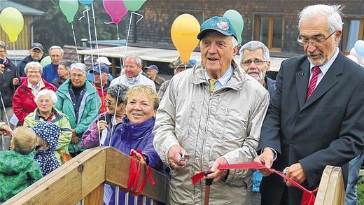 Der Sponsor: Josef Dorsch durchschneidet bei der Spielplatzeinweihung mit Regierungspräsident Paul Beinhofer das rote Band.