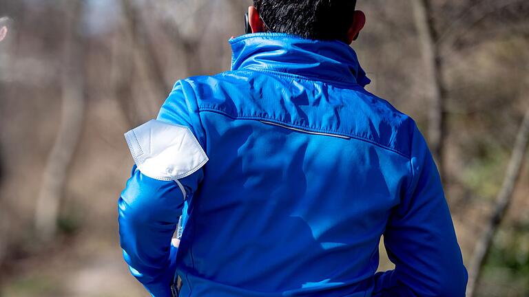 Ein Mann joggt in einem Park       -  Langsam zurück ins Training: Nach einem Infekt sollte man nicht direkt zum alten Pensum zurückkehren, sondern den Wiedereinstieg vorsichtig angehen.