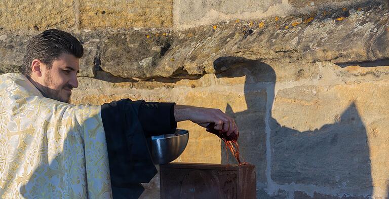 Vor der Segnung wurde der Chatschkar von Gemeindepfarrer Aygik Hovhannisyan mit Wasser und mit Wein symbolisch gewaschen.