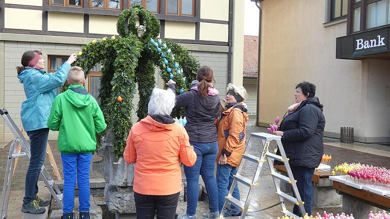 Nachdem das 'Green-Team' im Bauhof Buchs und Thuja an der Metallkrone befestigt hatte, konnte die zweite Gruppe am Rathausbrunnen die Ostereier und die Pflanzkörbchen anbringen.