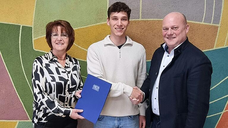 Geschäftsleitende Beamtin Ulla Sippach (links) und Bürgermeister Georg Seiffert (rechts) gratulieren Andreas Löflund.