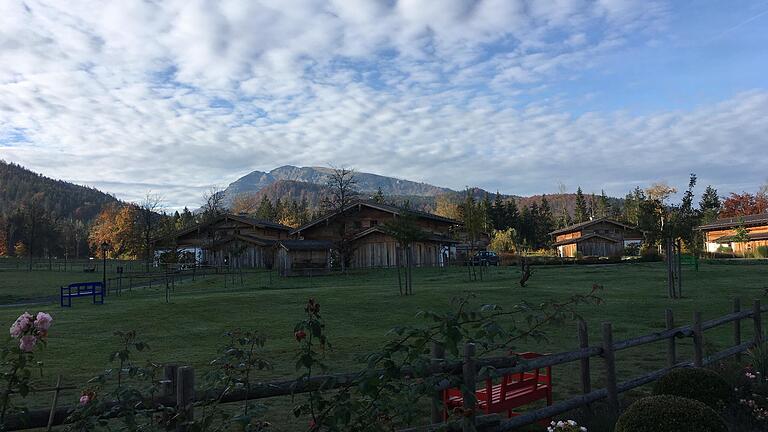 Die sieben auf grüner Wiese errichteten Chalets auf Gut Steinbach in Reit im Winkl passen sich in die Landschaft der Chiemgauer Alpen ein, ohne zu stören. Der Unterberg im Hintergrund liegt bereits im österreichischen Tirol.