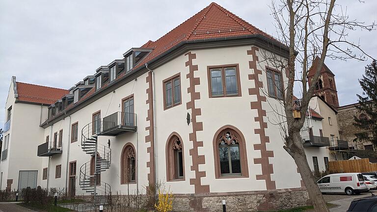 Kapitelhaus des ehemaligen Klosters der Prämonstratenserinnen in Unterzell, erbaut durch den Würzburger Fürstbischof Julius Echter 1608 bis 1613. Im Erdgeschoss befindet sich der Kapitelsaal mit gotischen Kathedralen-Fenstern mit Maßwerk. Links zu sehen ist der Ausläufer des Ostflügels vom Konventbau; rechts der ehemalige Ostflügel, seit 2021 mit Wohnungen; im Hintergrund der Südturm und das Kirchenschiff.