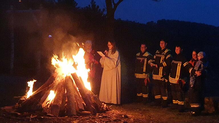 Pastoralreferentin Katrin Fuchs (Zweite von links) segnete vor zahlreichen Besuchern das eben entfachte Homburger Osterfeuer.