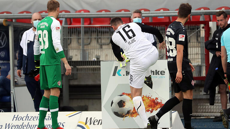 Jasmin Fejzic (Eintracht Braunschweig, mitte) tritt vor Wut über die 1:2-Niederlage von Braunschweig gegen die Würzburger Kickers in einen Werbewürfel. Robert Herrmann (re.) und Hendrik Bonmann (beide FC Würzburger Kickers) beobachten die Szene. Jasmin Fejzic (Eintracht Braunschweig, mitte) tritt vor Wut über die 1:2-Niederlage von Braunschweig gegen die Würzburger Kickers in einen Werbewürfel. Robert Herrmann (re.) und Hendrik Bonmann (beide FC Würzburger Kickers) beobachten die Szene.