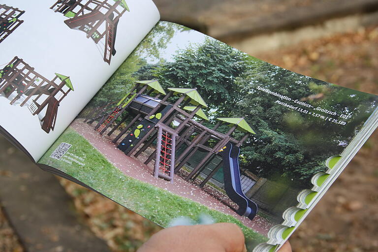 Bauhofleiter Michael Finster zeigt ein Prospekt, das den bestellten Hauptspielturm für den Spielplatz in der Nördlichen Allee zeigt.