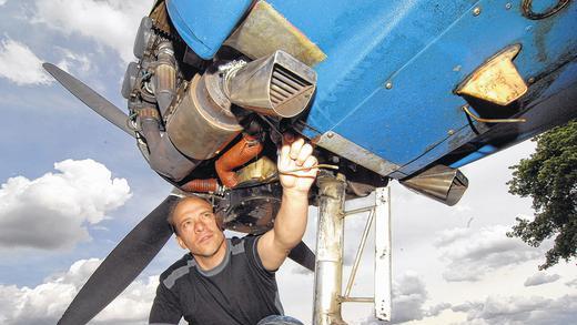 Damit es leiser am Himmel ist: Flugzeugwart Christian Frizlen vom Flugsportclub Würzburg am Schenkenturm zeigt im Hangar den 2500 Euro teuren Schalldämpfer mit Gegenschalltechnik, der das Auspuffgeräusch des Schleppfliegers dämpfen soll.