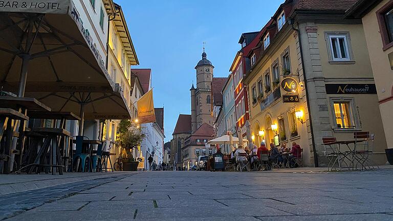 Die Volkacher Altstadt am Abend eines milden Oktobertages. Zahlreiche Menschen flanieren durch die Straßen oder sitzen draußen mit einem Glas Wein.&nbsp;