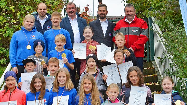 Die Erstplatzierten beim Schwimmwettbewerb der Kreiswasserwacht Rhön-Grabfeld gemeinsam mit (hinten, von links) Stefan Bergmann, stellvertretender Vorsitzender der Kreiswasserwacht, Mellrichstadts stellvertretendem Bürgermeister Thomas Dietz, BRK-Kreisjugendwart Michael Hellmuth und BRK-Kreisgeschäftsführer Ralf Baumeister.