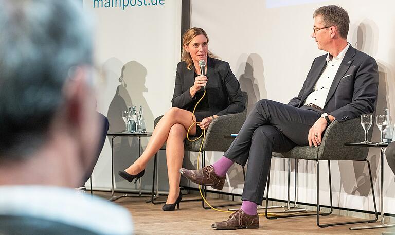 Die Dritte Bürgermeisterin, Judith Roth, gemeinsam mit Christian Schuchardt auf der Bühne einer Veranstaltung zur Multifunktionsarena in Würzburg.