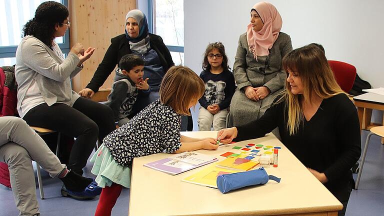 Arzu Gümüshan (rechts) und Rafah Wassouf (hinten links) arbeiten mit Eltern und Kindern im Hippy-Programm. Arzu Gümüshan (rechts) und Rafah Wassouf (hinten links) arbeiten mit Eltern und Kindern im Hippy-Programm.
