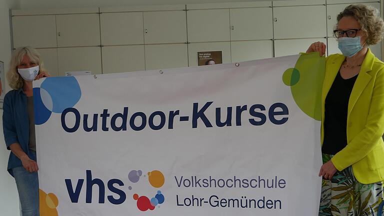 Silvia Brey und Vhs-Leiterin Susanne Duckstein mit dem Banner der Volkshochschule für das Outdoorprogramm, das unter Einhaltung der aktuellen Hygienebedingungen jetzt startet.