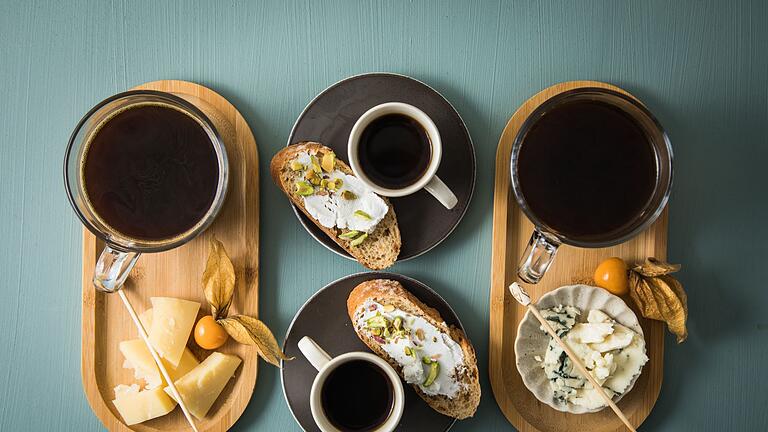 Tabletts mit Kaffee, Espresso und verschiedenem Käse       -  Klingt ungewöhnlich, aber passt: Zum Espresso oder Kaffee muss es nicht immer Süßes sein. Es passen etwa auch ein Le Gruyere, Ziegenfrisch- oder Blauschimmelkäse.