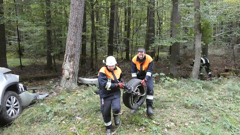 Unter anderem der linke Vorderreifen samt Aufhängung flog in den Wald. Die Einsatzkräfte der Feuerwehr Untersteinbach sammelten die Fahrzeugtrümmer am Unfallort ein.