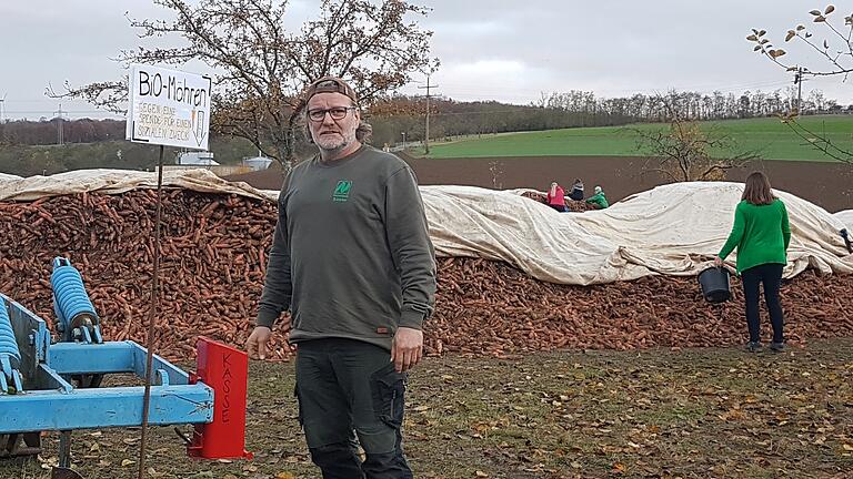Bernhard Sauer auf seinen Acker vor einem Karotten-Berg, von denen er mehrere platziert hat. Bernhard Sauer auf seinen Acker vor einem Karotten-Berg, von denen er mehrere platziert hat.