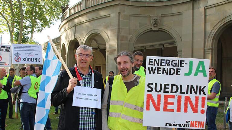 Rudolf Rüger und Peter Fella aus Greßthal gehörten zu den Demonstranten, die gestern vor dem Bad Kissinger Regentenbau zum Start der Erörterungstermins ihren Protest äußerten. Fotos: Ralf Ruppert       -  Rudolf Rüger und Peter Fella aus Greßthal gehörten zu den Demonstranten, die gestern vor dem Bad Kissinger Regentenbau zum Start der Erörterungstermins ihren Protest äußerten. Fotos: Ralf Ruppert