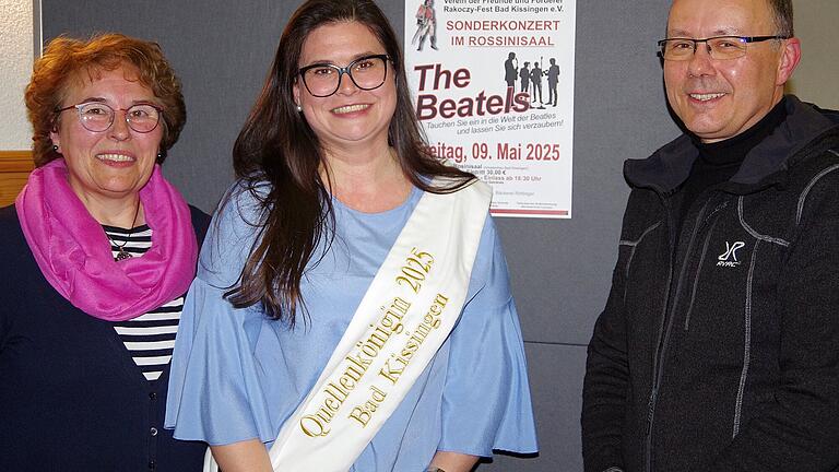 Quellenkönigin 2025 Julia Meder       -  Die Vorsitzende der Freunde und Förderer Rakoczy-Fest, Anna Krug (von links), Quellenkönigin Julia Meder und Bruno Heynen, Leiter der Veranstaltungsabteilung der Bayerischen Staatsbad GmbH, vor dem Plakat für das Sonderkonzert.