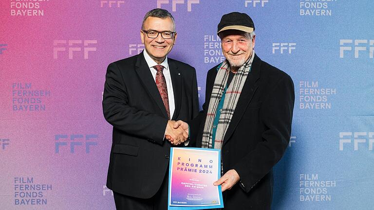 Medienminister Florian Herrmann (links) überreichte Bruno Schneyer vom Zeiler Capitol die Prämie.