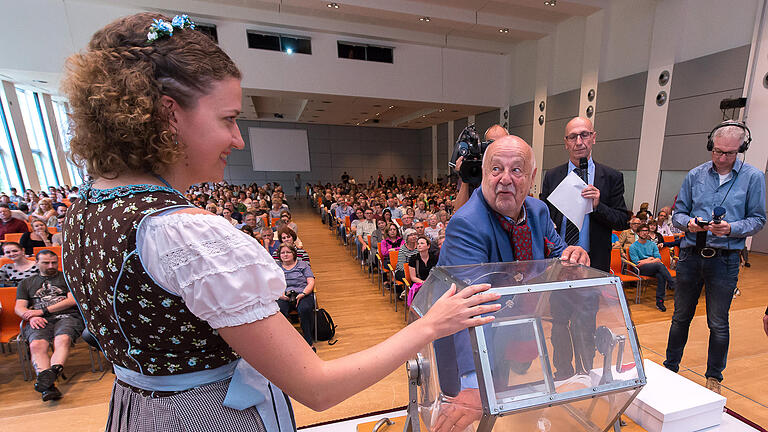 Die große Häuser-Verlosung       -  Wer bekommt die Lizenz zum Hauskauf? Herrmann Mees und das &bdquo;Volksfestgesicht 2016&ldquo;, Miriam Förtsch, an der Lostrommel.