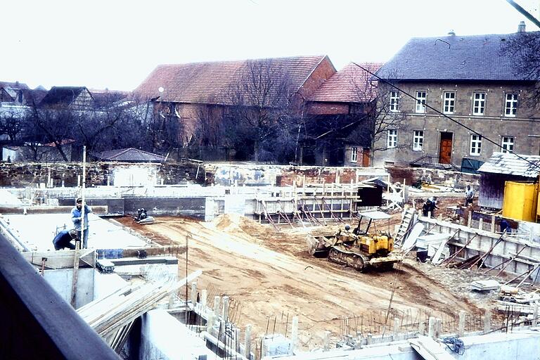 Für die Gründung der neuen Pfarrkirche mussten 39 Betonpfähle in den Untergrund gerammt werden. Hier die Baustelle 1969, im Hintergrund rechts das evangelische Pfarrhaus.