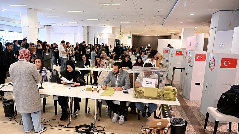 Stichwahl in Türkei - Wähler in München.jpeg       -  Eine Frau steht bei Ihrer Stimmabgabe zur Präsidentschaftswahl in der Türkei in einem Wahllokal in einem ehemaligen Kaufhaus in der Münchner Innenstadt.