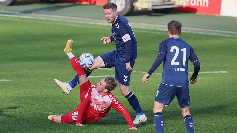 Akrobatisch versucht Philipp Harlaß (am Boden) vom TSV Aubstadt den Ball gegen Lukas Nottbeck und Luca Schlax (rechts) vom 1. FC Köln II zu verteidigen.