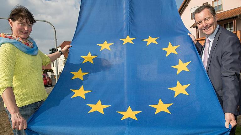 Die Mitte der Europäischen Union       -  Landwirtin Karin Keßler und Bürgermeister Jürgen Götz präsentieren in Gadheim die Europaflagge.