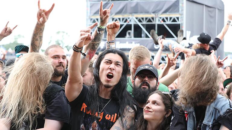 Lange Haare und 'Pommesgabel': Metalheads in der ersten Reihe unmittelbar vor der Bühne - und im Hintergrund schwebt ein Crowdsurfer nach vorn. Lange Haare und 'Pommesgabel': Metalheads in der ersten Reihe unmittelbar vor der Bühne - und im Hintergrund schwebt ein Crowdsurfer nach vorn.