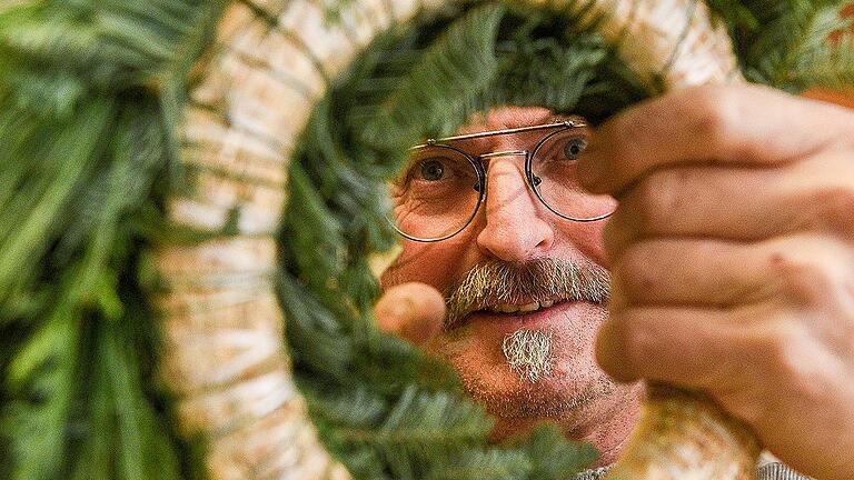 Durchblick: Wolfgang Müller mit einem Rohling aus Stroh und viel Tannengrün. Er macht Adventskränze in 20 Minuten &ndash; Anfänger brauchen doppelt so lang.