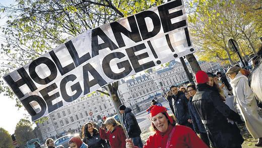 Hollande verschwinde! Mit diesem Banner nahm diese Demonstrantin am Samstag in Paris an den Protesten gegen die Steuerpolitik des französischen Präsidenten François Hollande teil.