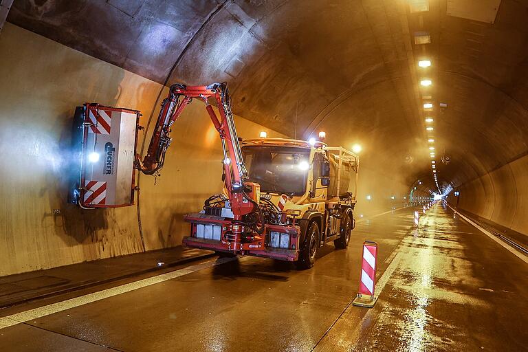 Mit einer großen Bürste am Gefährt schrubbt der Arbeiter die Innenwände der Tunnelröhre.