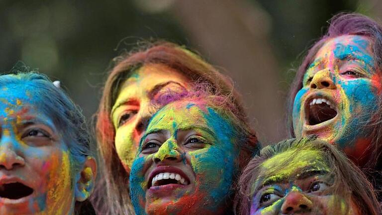 Feierlichkeiten zum Holi-Fest in Mumbai: Holi, das Fest der Farben, läutet in Indien den Frühling ein. Foto: Rajanish Kakade/AP/dpa       -  Holi wird mittlerweile nicht nur in Indien gefeiert. Welchen Ursprung hat das traditionelle Fest und warum wird mit Farben geworfen?