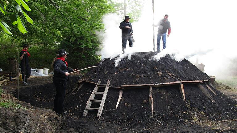 Die Frammersbacher Köhler regulieren die Glut im Meiler durch Öffnen und Schließen von Löchern im Erdmantel. Die Frammersbacher Köhler regulieren die Glut im Meiler durch Öffnen und Schließen von Löchern im Erdmantel.