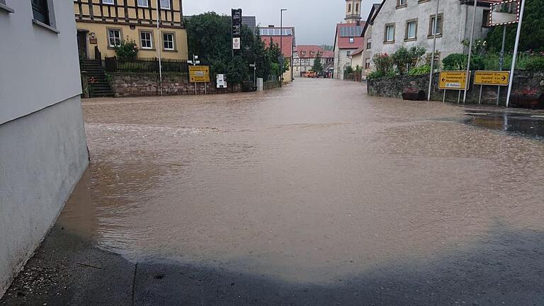Das Bild zeigt die von Wasser überflutete Ortsdurchfahrt von Michelau am Freitagvormittag, während der erste Hochwasserwelle im Ort. Am späten Nachmittag war die Straße erneut überflutet. Das Bild zeigt die von Wasser überflutete Ortsdurchfahrt von Michelau am Freitagvormittag, während der erste Hochwasserwelle im Ort. Am späten Nachmittag war die Straße erneut überflutet.