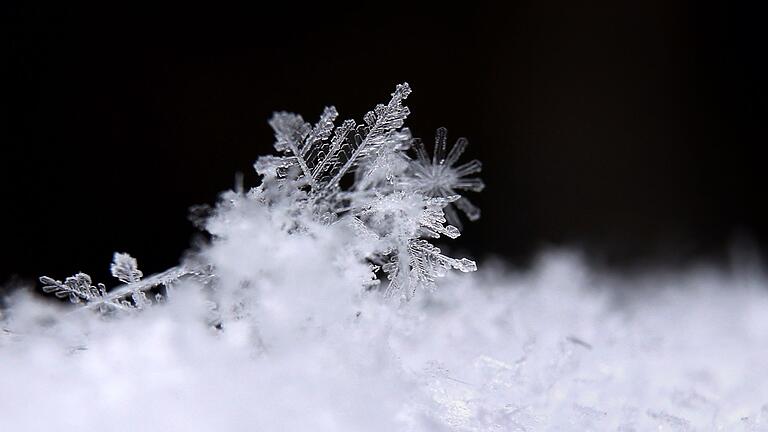 Schneeflocken Eiskristalle in Bayern       -  Auch am Donnerstag, 26. Januar 2023, fällt nur ein wenig Schnee in Bayern.