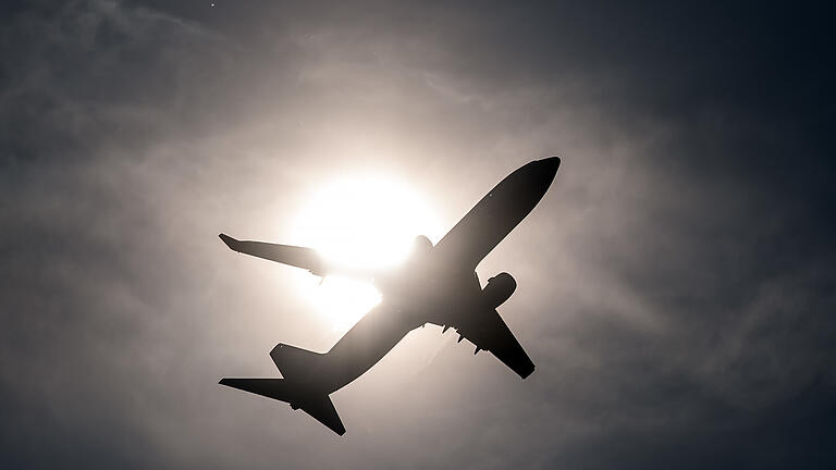 Flugzeug startet.jpeg       -  Ein Flugzeug startet vom Flughafen in Düsseldorf und fliegt an der Sonne vorbei.