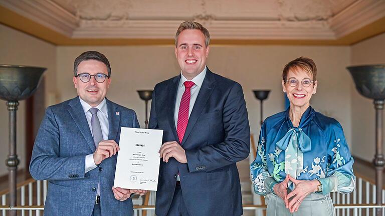 Landrat Christoph Schauder überreicht Ludger Krug (Mitte) die Ernennungsurkunde zum Beamten auf Lebenszeit. Den Glückwünschen schloss sich Sozialdezernentin Elisabeth Krug an.