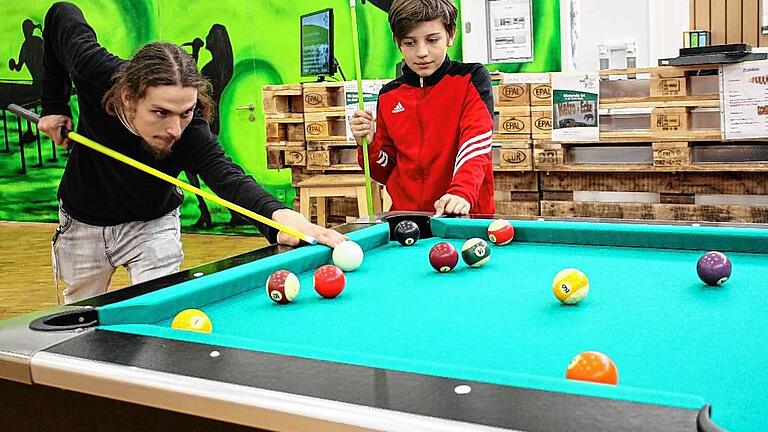 Erzieher Felix Eckstein (links) und Marlon Jarmer nutzen die Pause der Hausaufgabenbetreuung und spielen Billard.