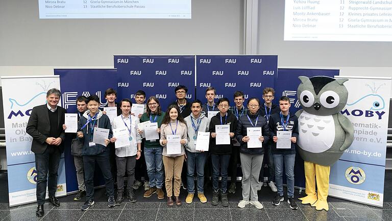 FAU-Präsident Prof. Dr. Joachim Hornegger beim Festakt der 62. Mathe-Olympiade mit Yizhou Huang (3. von rechts) und zwölf weiteren Preisträgerinnen und -trägern, die den 2. Preis erhalten haben.