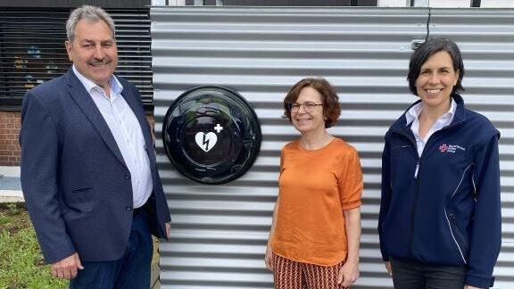 Bürgermeister Lorenz Strifsky, Rektorin Claudia Nöth und Dr. Daniela Gerhard (von links) freuen sich über die günstige Lage des neuen Defibrillators.&nbsp;