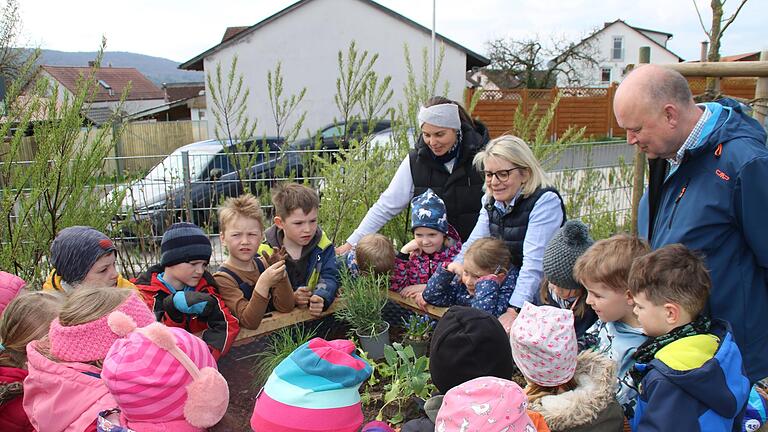 Kinder gießen das frisch gepflanzte Hochbeet.       -  Kinder gießen das frisch gepflanzte Hochbeet.