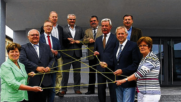 Netzwerker: Auf der Treppe des Rathauses in Oerlenbach spannen die Bürgermeister der Allianz Oberes Werntal ein gemeinsames Netz mit (von links)  Ruth-Hanna Gube (Geldersheim), Siegfried Erhard (Oerlenbach), Peter Neubert (Bergrheinfeld), Peter Pfister (Waigolshausen), Willi Warmuth (Dittelbrunn), Günter Jakob (Wasserlosen), Peter Seifert (Niederwerrn), Arthur Arnold (Euerbach) und Edeltraud Baumgartl (Werneck) sowie oben rechts Reinhold Stahl (Poppenhausen).